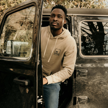 MAN GETTING OUT OF A CAR WEARING ORGANIC COTTON HOODIE