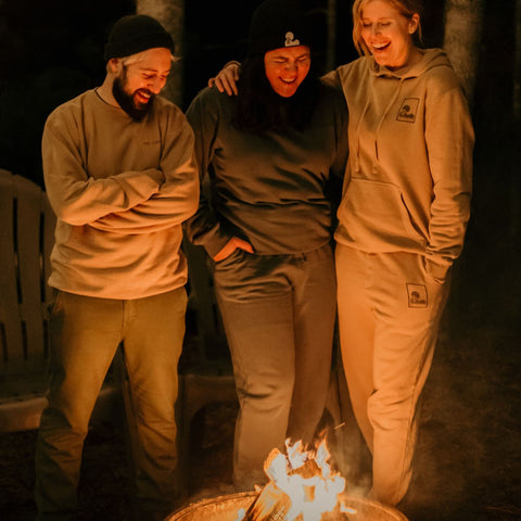 friends standing around a campfire