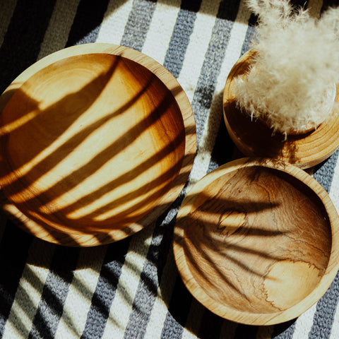 bamboo cutting board and olive wood bowl with salad in it