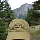 Green cap with 'Sol Terra Shop' logo in a forest setting with mountains in the background