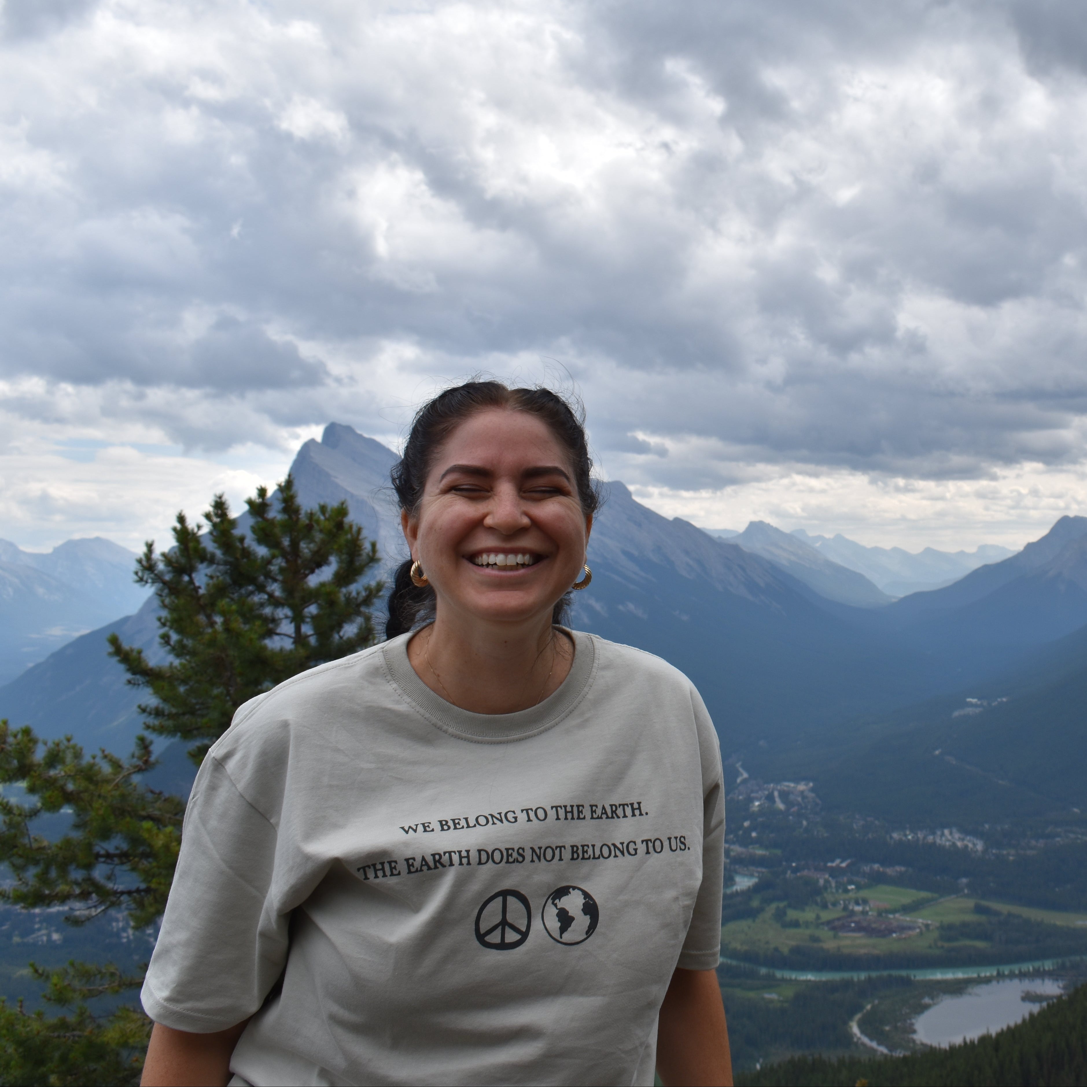 girl wearing we belong to the Earth t-shirt with mountain background