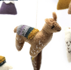 close up of felt llama attached by strong to baby mobile
