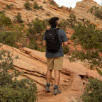 Person hiking on a rocky trail with a scenic mountain landscape