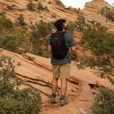 Person hiking on a rocky trail with a scenic mountain landscape