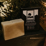 natural evergreen tree soap sitting on ledge with greenery